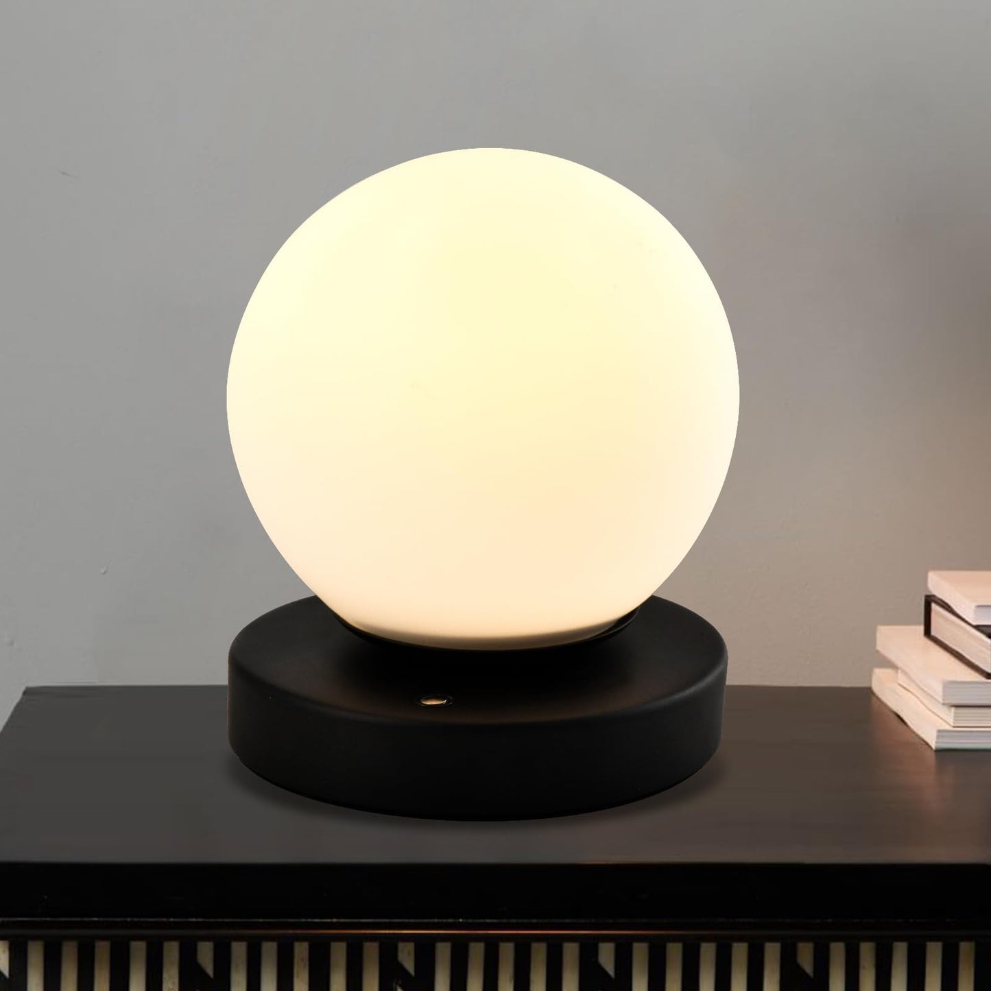 Tischlampe mit kugelförmigem Opalglas und warmweißem Licht auf schwarzer Basis