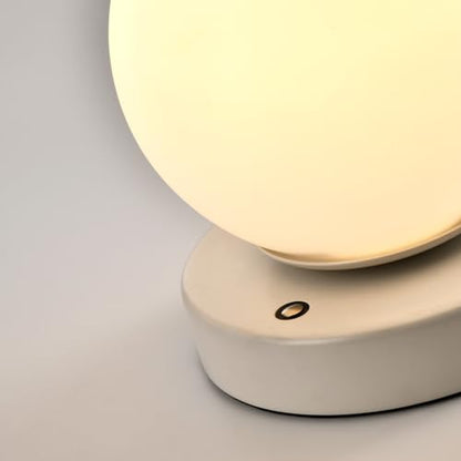 Tischlampe mit weißem Sockel und warm leuchtender Kugel, Detail Bedientaste
