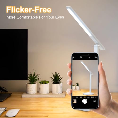 LED-Schreibtischlampe, weiß, mit ausklappbarem Leuchtenarm über Smartphone in der Hand