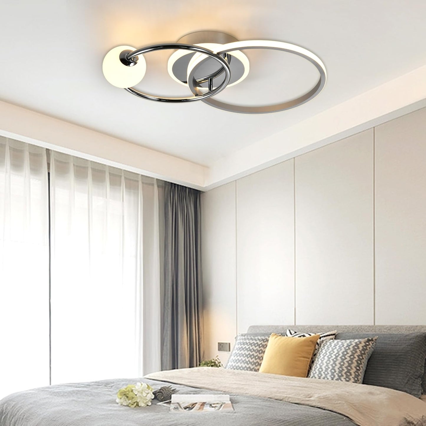 LED-Deckenleuchte mit rundem Ring, chromfarbenem Gestell und weißem Leuchtring über dem Bett