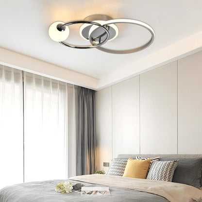 LED-Deckenleuchte mit rundem Ring, chromfarbenem Gestell und weißem Leuchtring über dem Bett