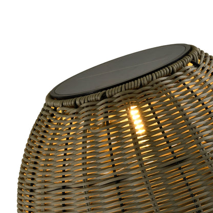 Rattanschirm einer Solarlampe mit warm leuchtenden LEDs im Detail, grau-beige