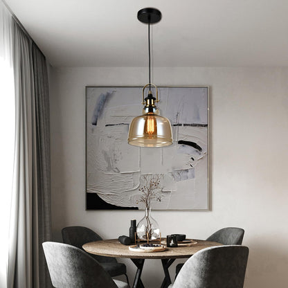 Pendelleuchte mit gläserner Glocke, goldfarbenem Metall und warm leuchtender Filamentlampe