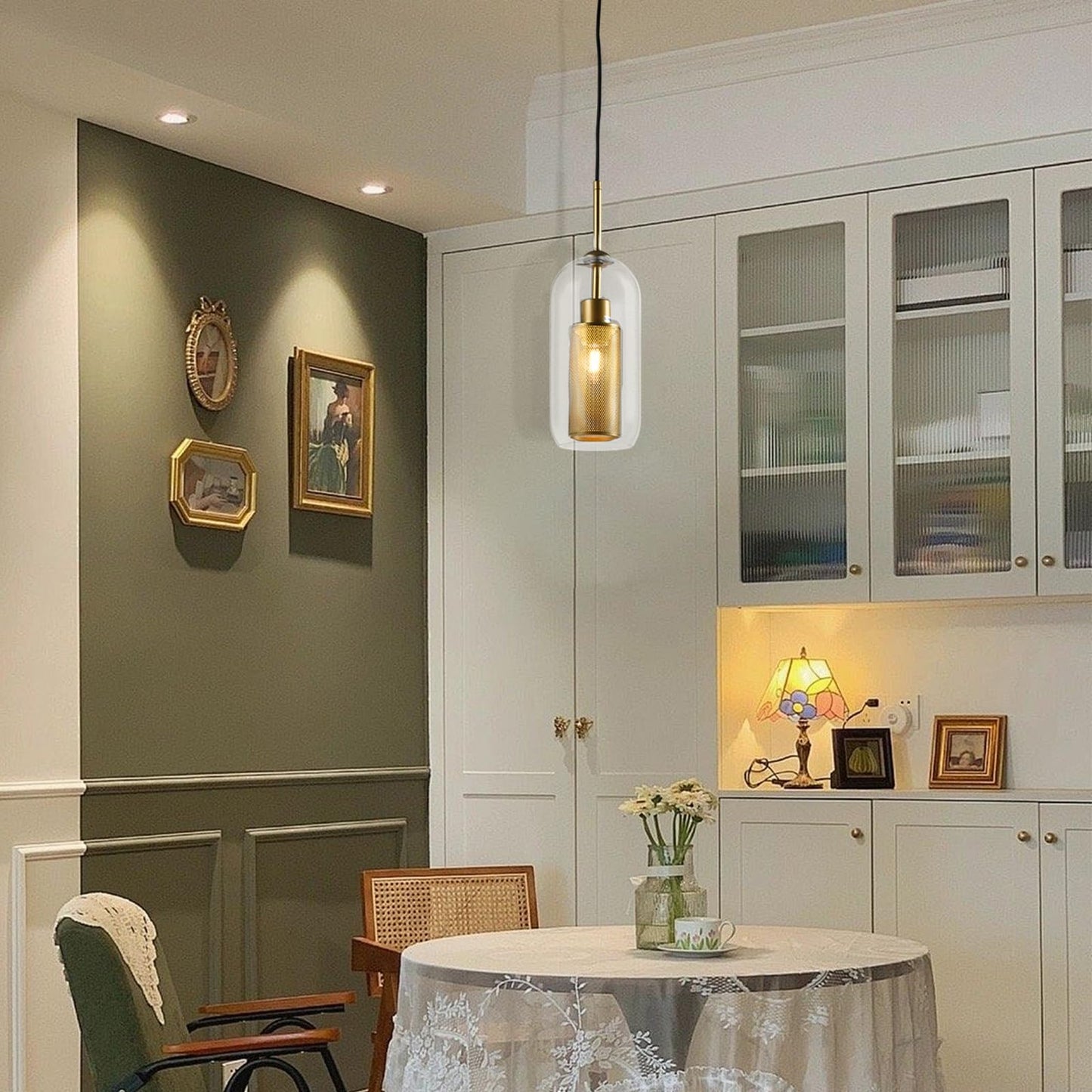 Pendelleuchte mit goldenem Metallgehäuse und klarem Glasschirm im Raum