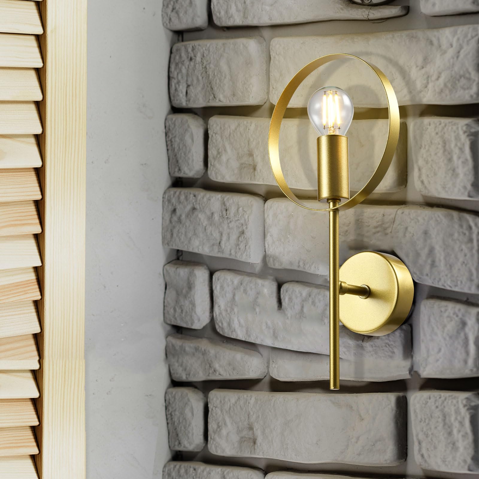 Goldene Wandleuchte mit rundem Metallring an Steinwand, E14-Fassung