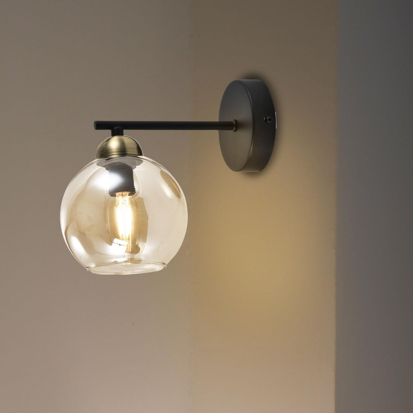 Retro-Wandleuchte mit klarer Glaskugel, mattschwarzem Wandarm und goldfarbener Kappe