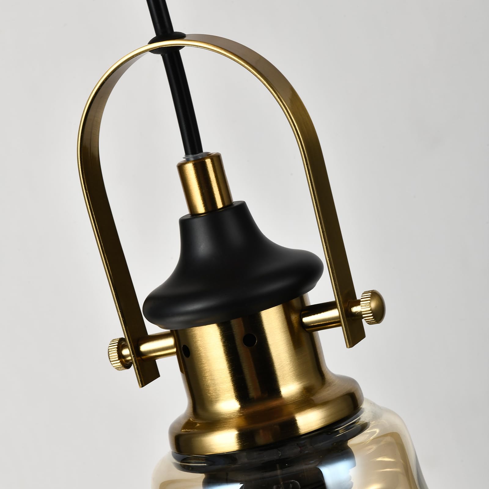 Pendelleuchte mit goldfarbener Metallstruktur, schwarzem Schirmteil und Glasglocke