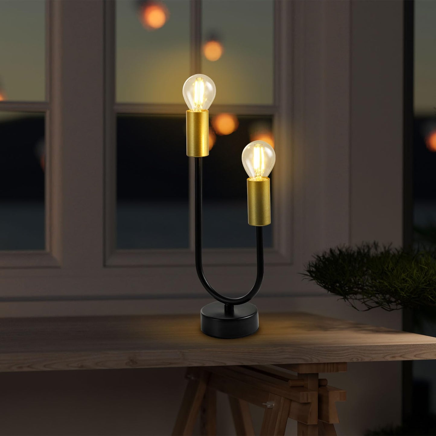 Zweiflammige Tischlampe mit zwei goldfarbenen Lampenfassungen und schwarzem Standfuß