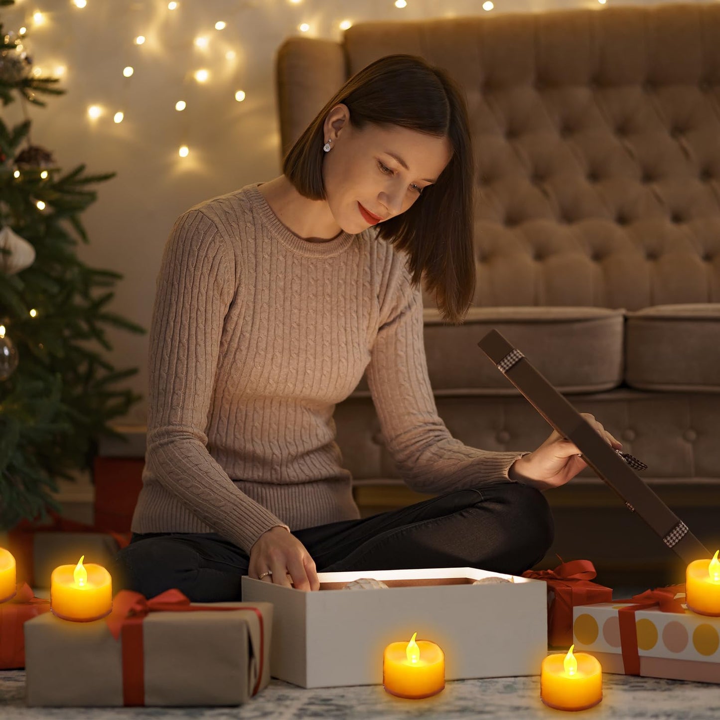 Mehrere gelbe LED-Teelichter auf dem Boden, warmes Flackern beim Geschenkeauspacken