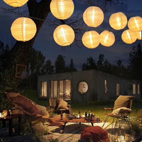 Solar-Lichterkette mit warmweißen Papier-Laternen am Abend über Terrasse und Liegestühlen