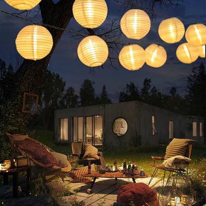 Solar-Lichterkette mit warmweißen Papier-Laternen am Abend über Terrasse und Liegestühlen