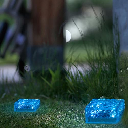 Blauer Solar-Glaspflasterstein-Würfel auf Rasen, nachts mit Lichtschein